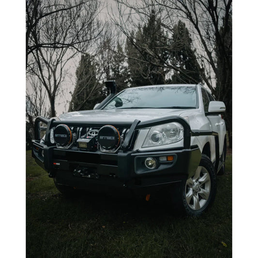 White off-road vehicle with black bull bar featuring Rockarmor Brushbar in premium steel