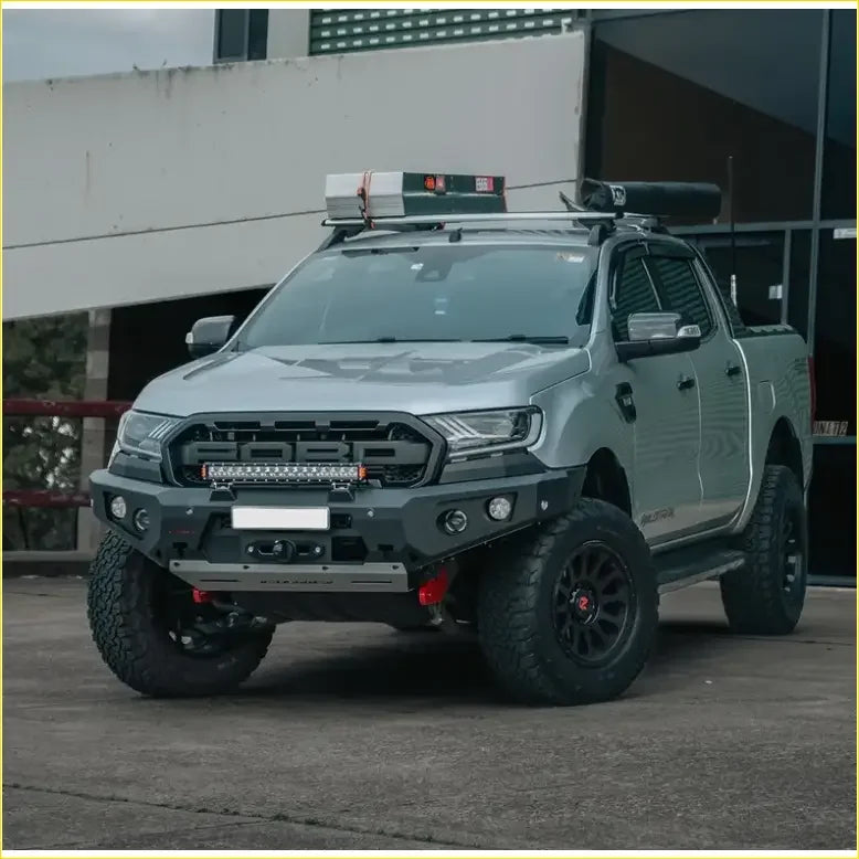 Silver ford ranger wildtrak with black off-road tires featuring rockarmor gt hoopless bullbar and rock sliders