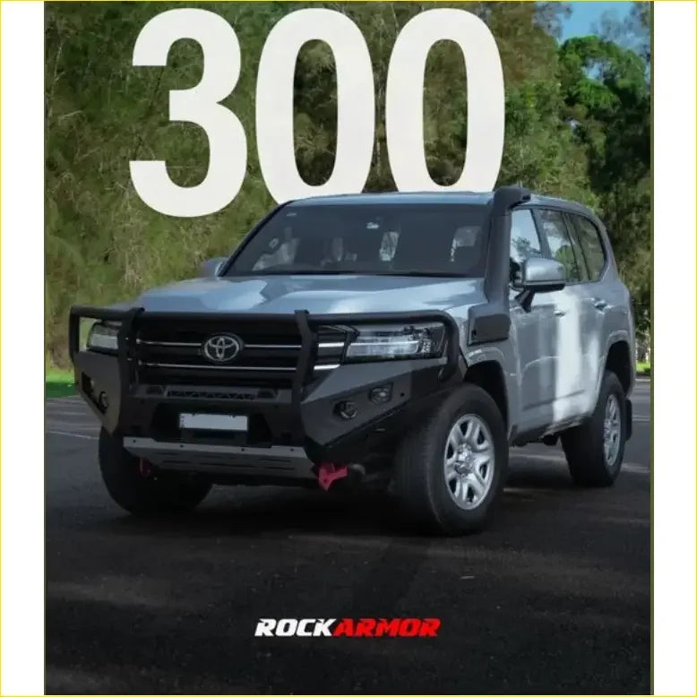 Silver toyota land cruiser 300 with black rockarmor front bumper and grille from rockarmor rock pack gt hoop bullbar and rock sliders