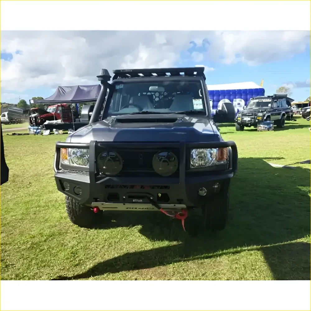 Black armored off-road toyota landcruiser 76 78 79 with rugged gt hoop bullbar roof rack and rock sliders