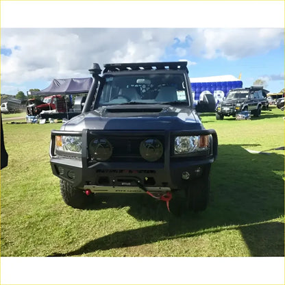 Black armored Toyota Landcruiser 79 with gt hoop bullbar and roof rack for off-road protection and utility